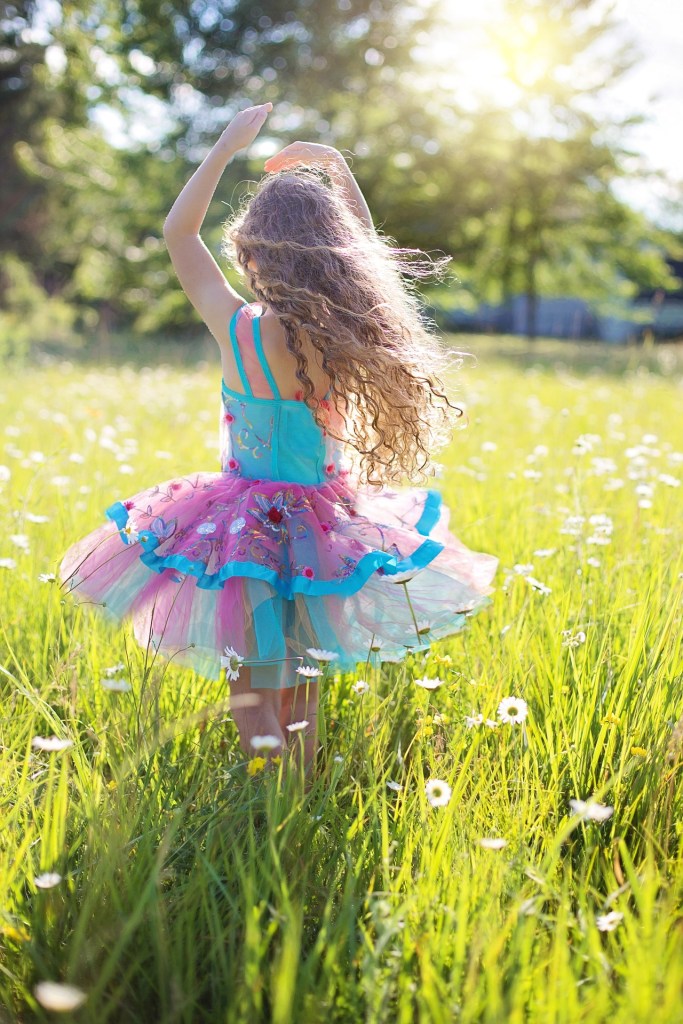A girl having fun twirling in the sunshine. Kids know how to have fun without stopping to worry about the falls or failures and that's exactly what we adults need to re-learn. Read the article how to have fun losing weight at www dot theerailivedin dot com